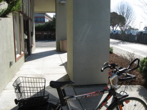 bicycle on rack, with front door just across the way.